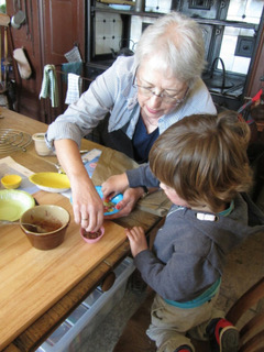 An older lady helping a small child with a craft activity.